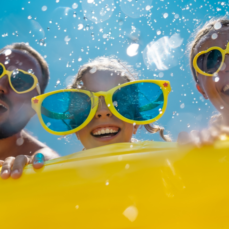 Family with sunglasses looking in pool