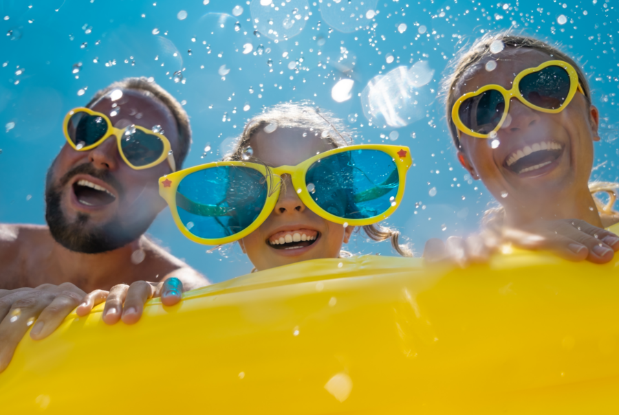 Family with sunglasses looking in pool