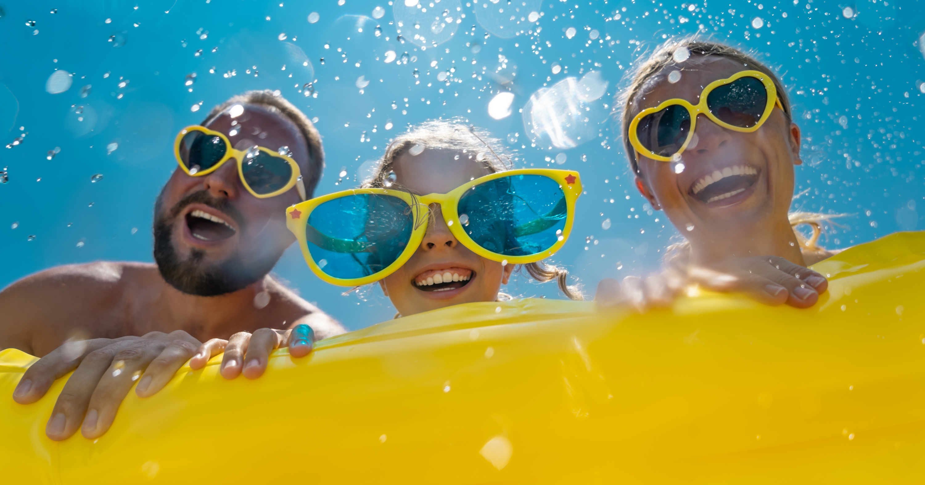 Family with sunglasses looking in pool